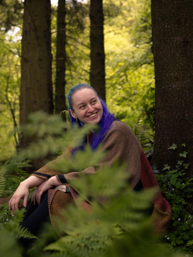 Shannon smiling in the woods.
